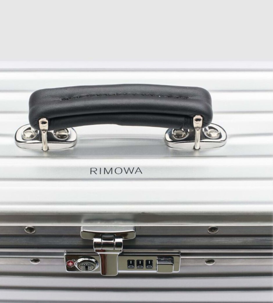Détail d'une valise en aluminium rainuré, poignée et fermoir